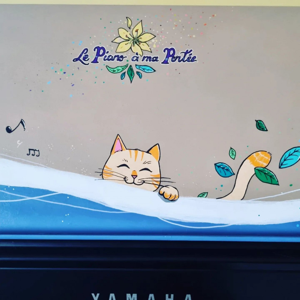 Vue de près du chat du milieu, espiègle, yeux fermés, partiellement caché derrière le décor