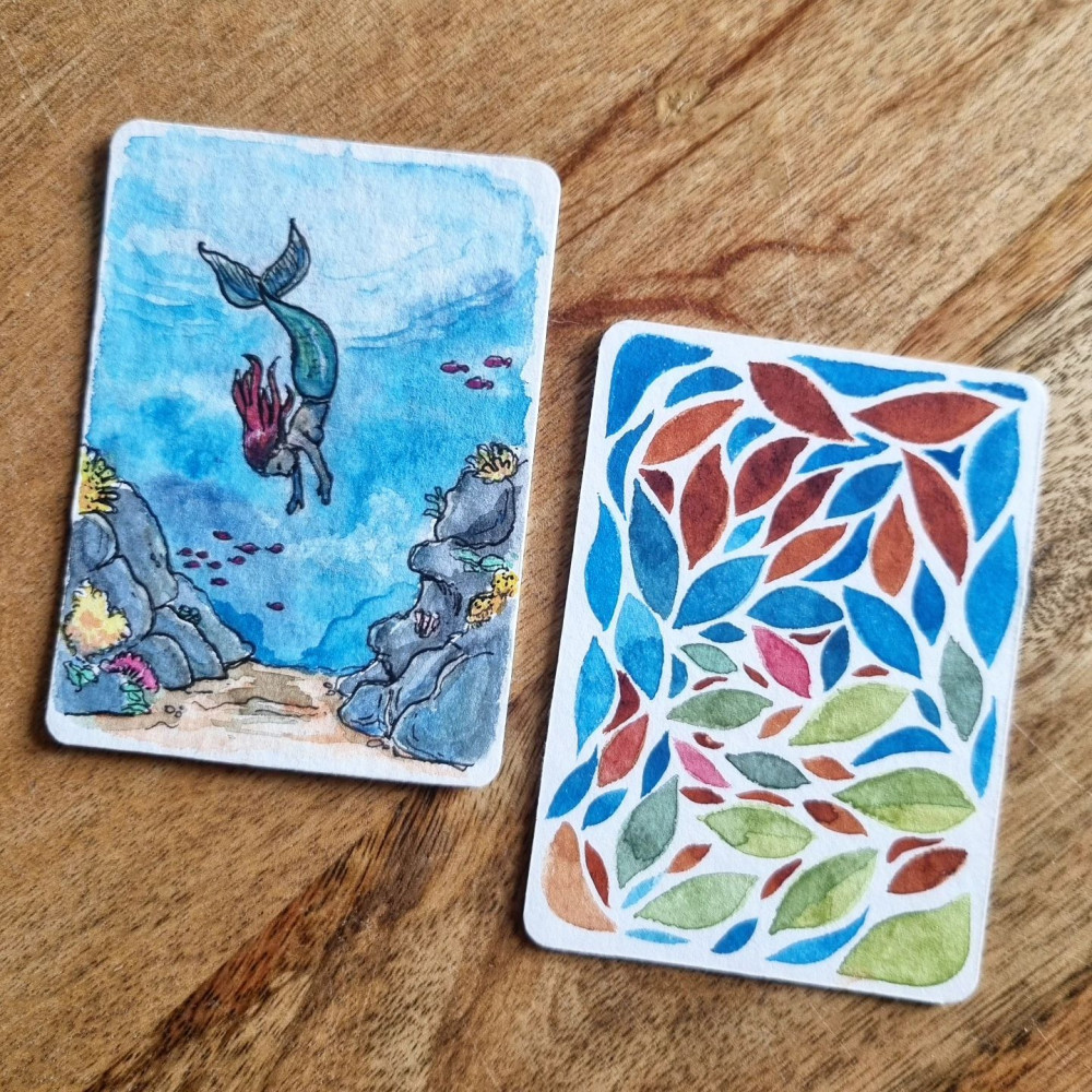 Deux petites cartes à l'aquarelle, une représentant une sirène plongeant au fond de l'océan, l'autre figurant un ensemble abstrait de pétales colorés.