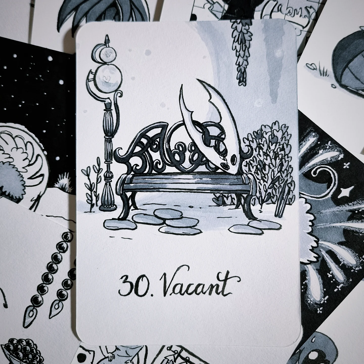 Un banc ouvragé dans un environnement rappelant Vertchemin éclairé par un lampadaire, et le masque du Hollow Knight appuyé contre le dossier du banc