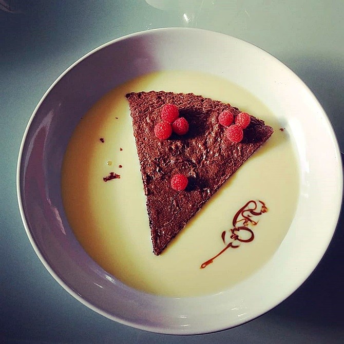 Part de fondant au chocolat maison baignant dans la crème anglaise + petit zigouigoui fait avec du chocolat et des framboises du jardin
